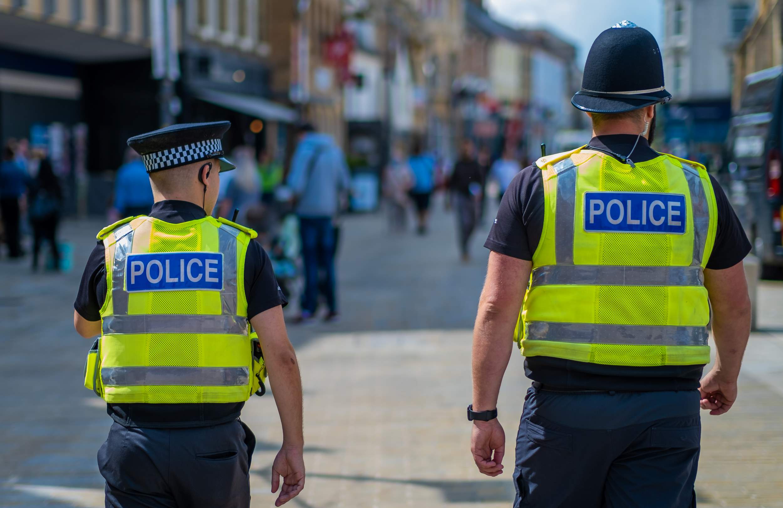 Uniformed police officers in high viz patrolling a busy city centre