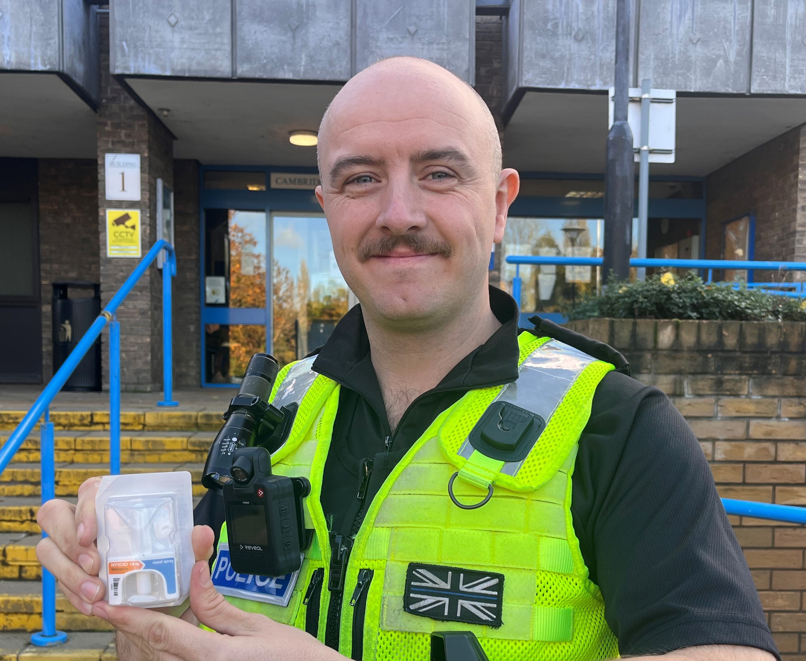 A policing officer holding some spray. 