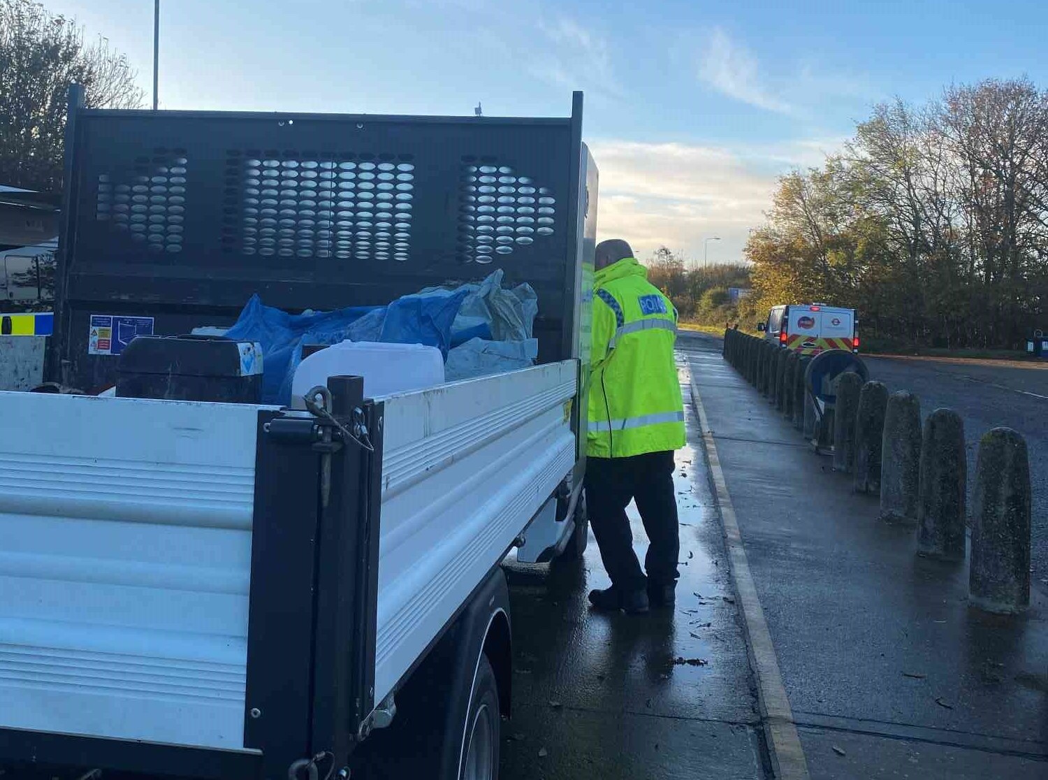 A police officer speaking with a van driver through their driver's window