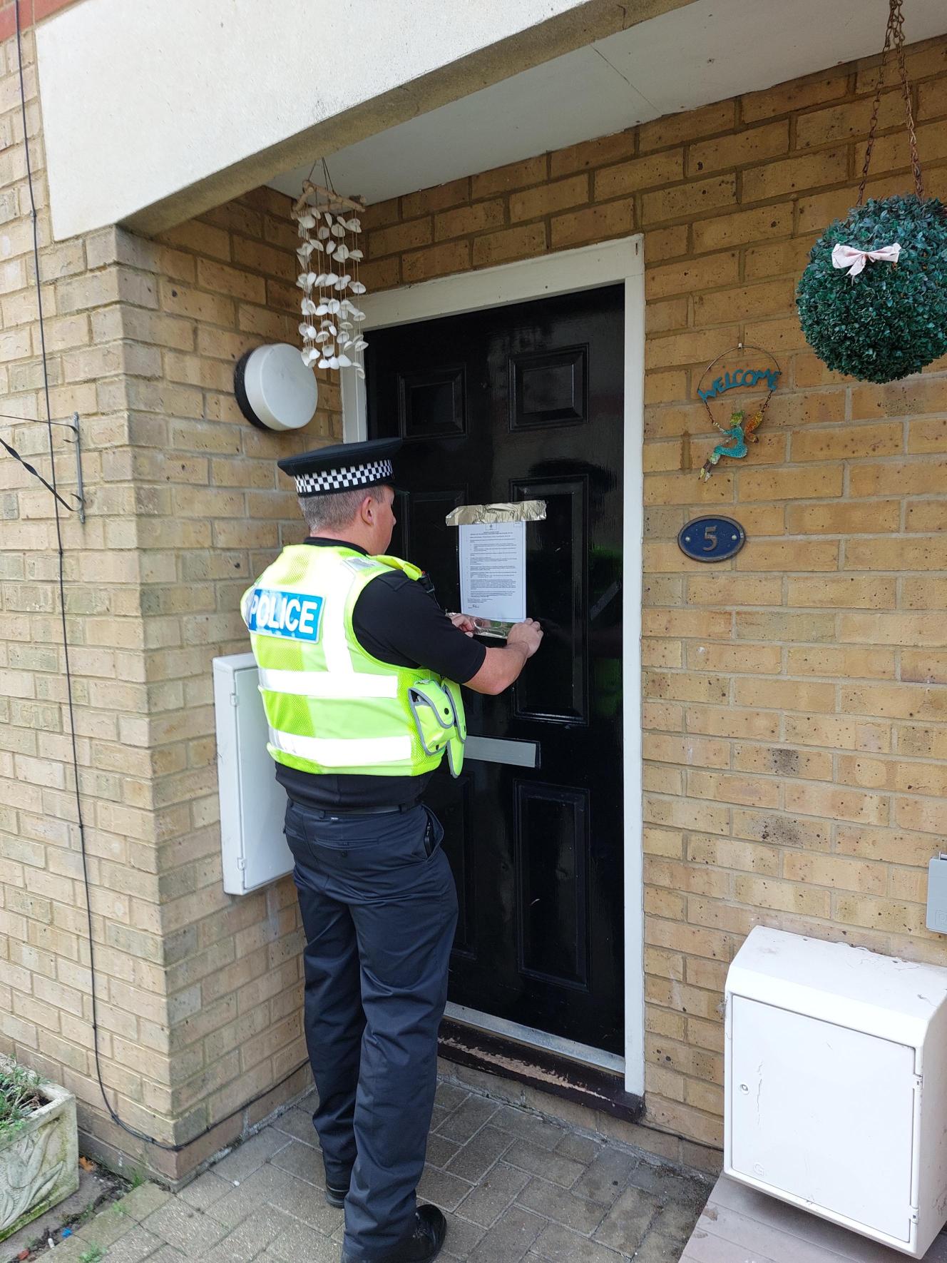 Police officer with the closure order notice