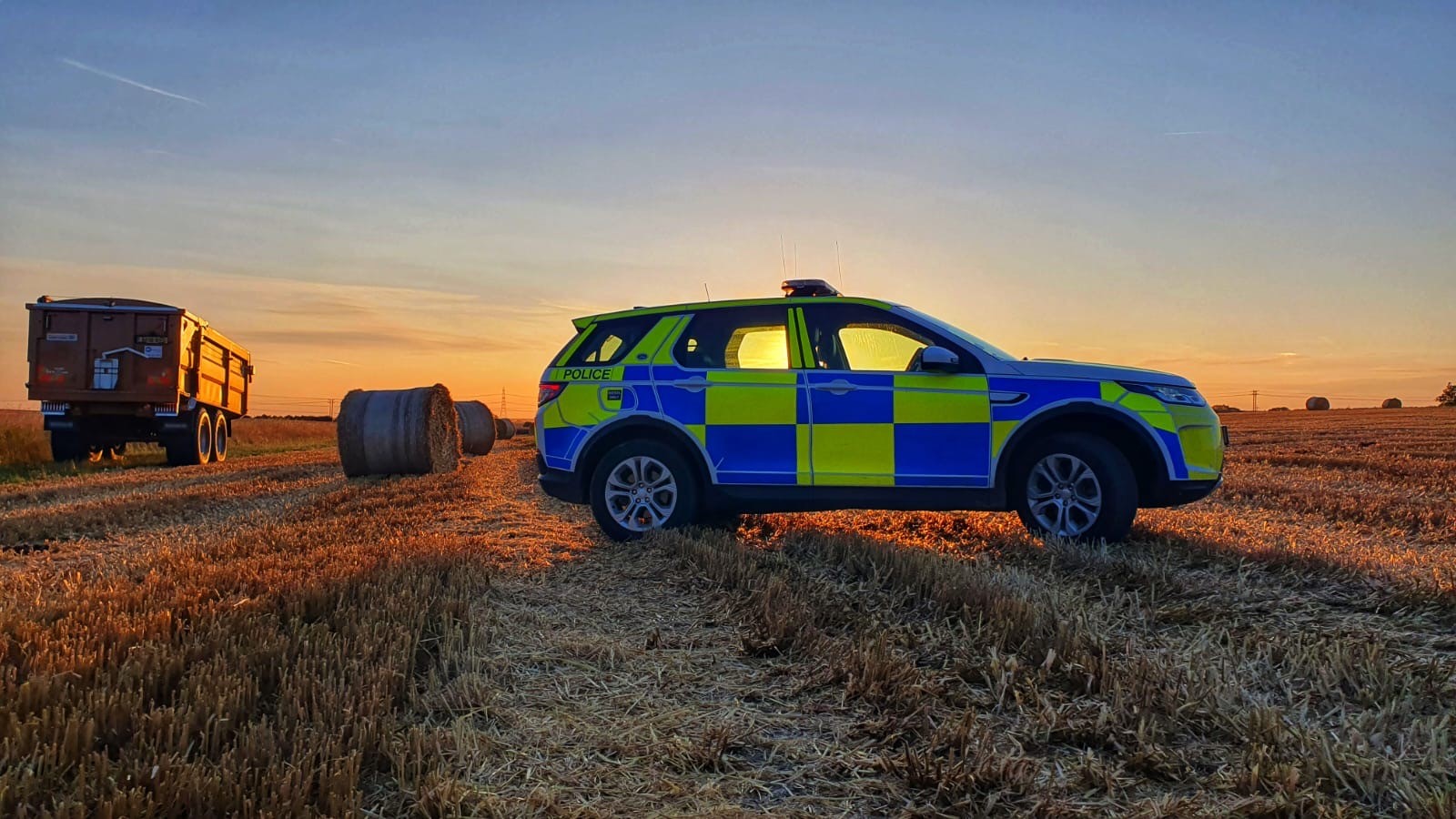 A police car in a rural setting at sunrise