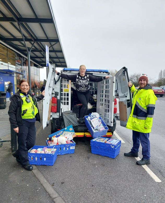 PCSOs with Tesco staff loading gifts into a police van