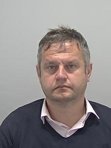 A custody photo of a dishevelled man. 