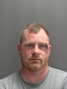 A custody photo of a dishevelled man. 