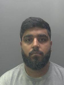 A custody photo of a man looking glum. 