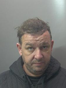 A custody photo of a dishevelled man. 