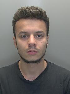 A custody photo of a man looking glum. 