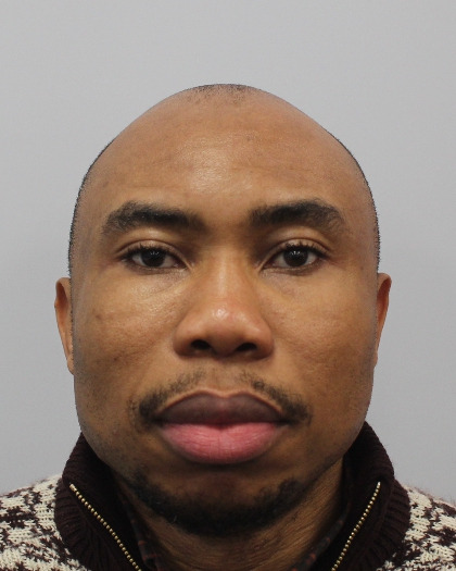 A close-up of a person with short hair, wearing a patterned zip-up sweater, shown against a plain background. The image is clear and focused, highlighting the facial features.