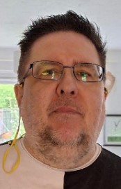 A photo of a man wearing glasses. 