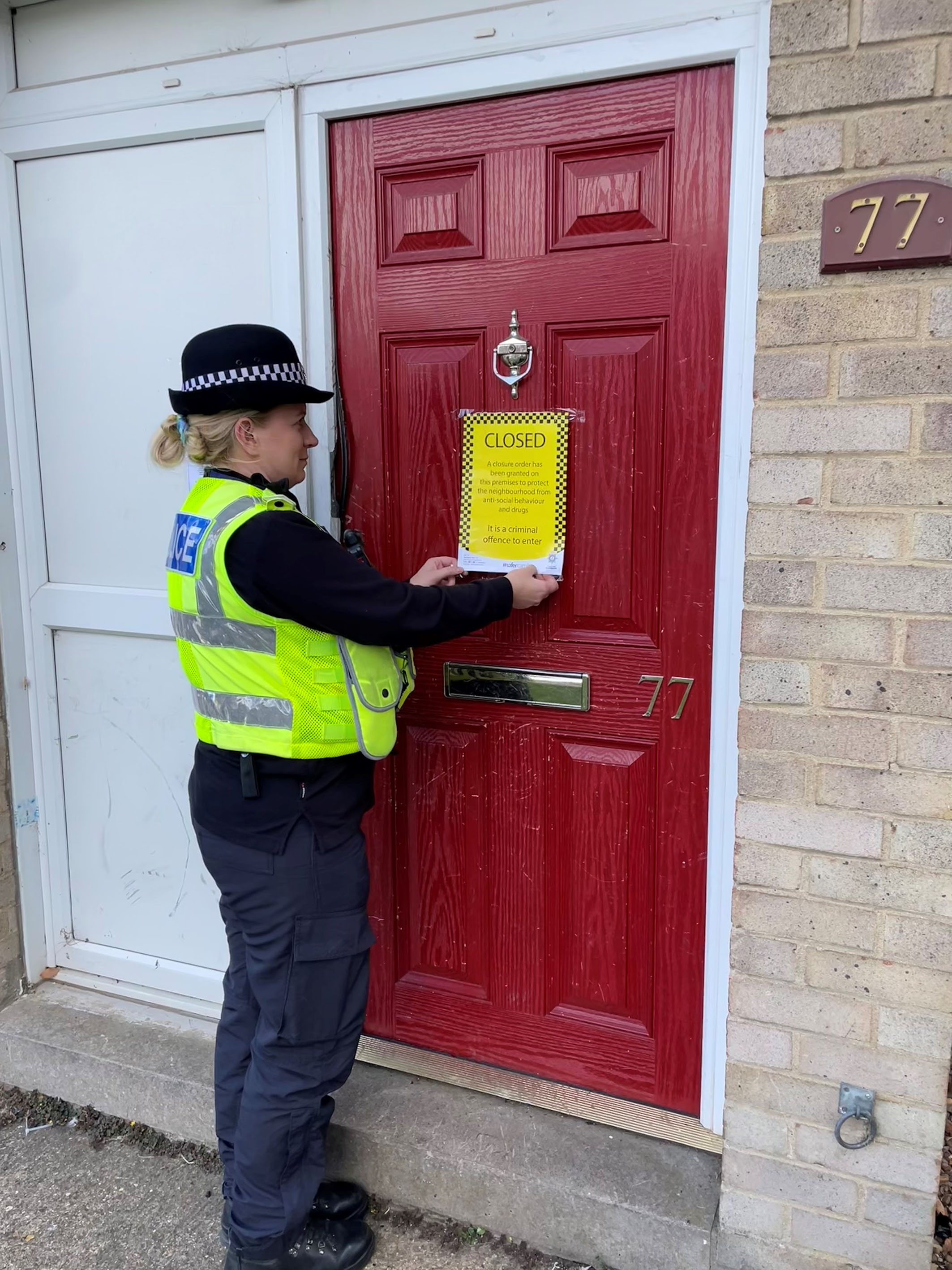 Police officer putting a closure order sign up