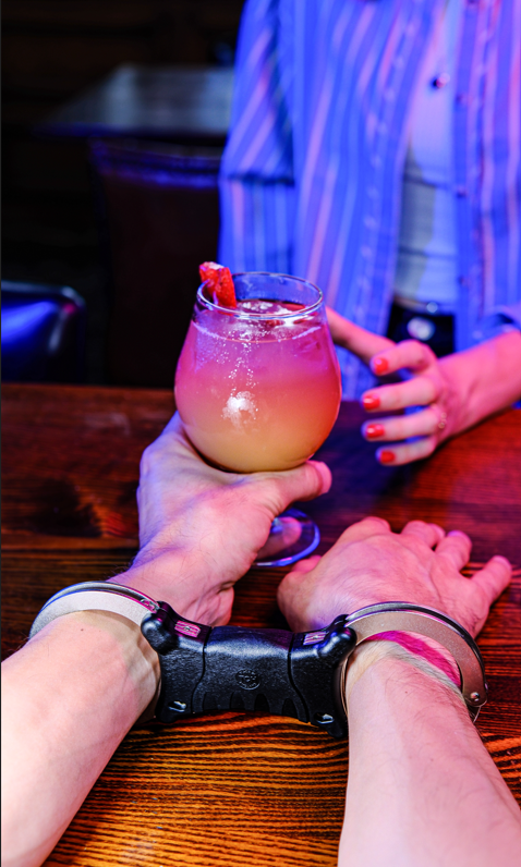 Handcuffed hands and a drink
