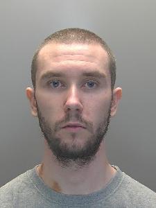 A custody photo of a man looking glum. 