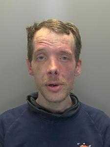A custody photo of a dishevelled man. 