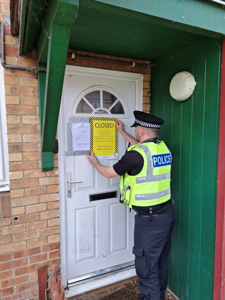 Police officer putting up closure order signs