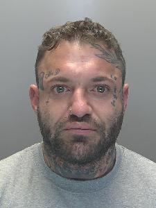 A custody photo of a man with tattoos on his face. 