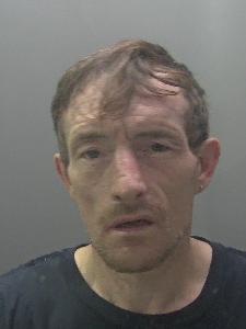 A custody photo of a dishevelled man. 
