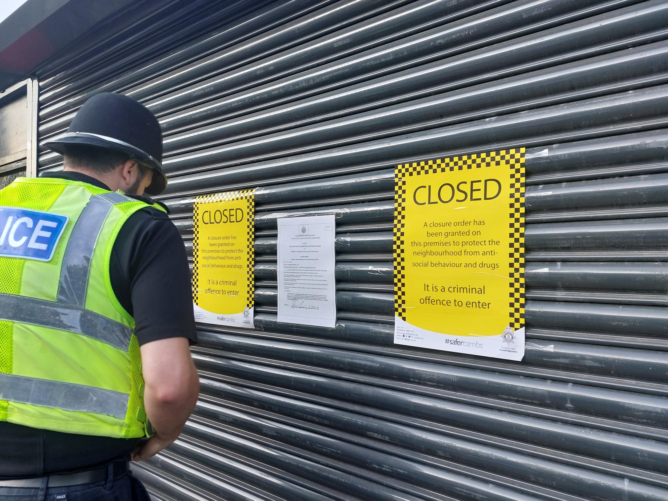 A police officer attaching the closure order to the shop