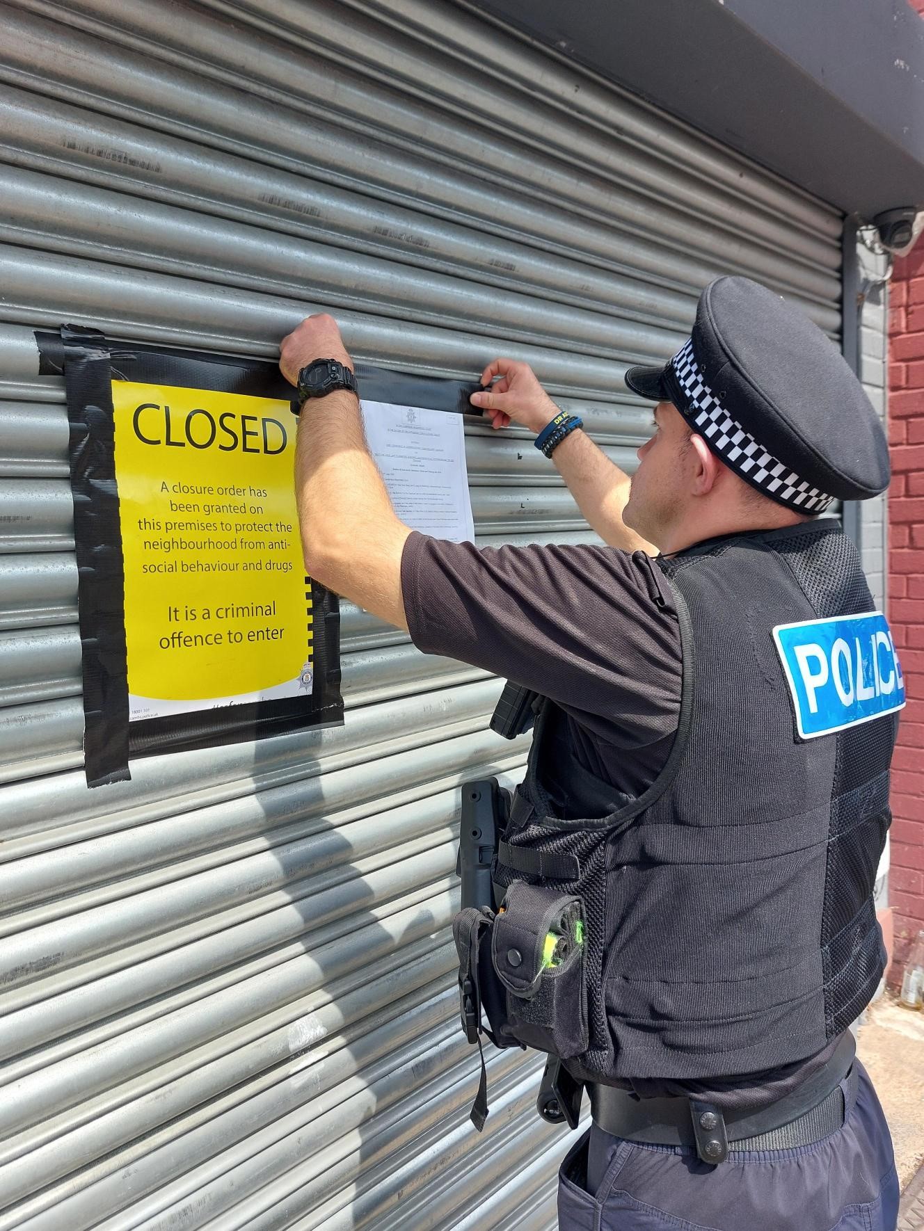 Police officer putting up closure order signs