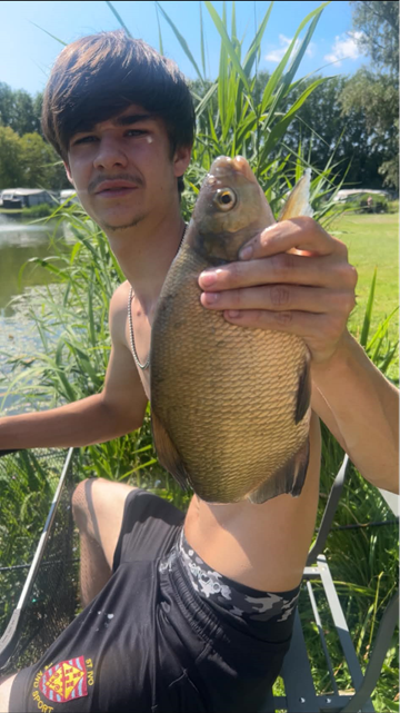 A picture of a teenager holding a fish. 