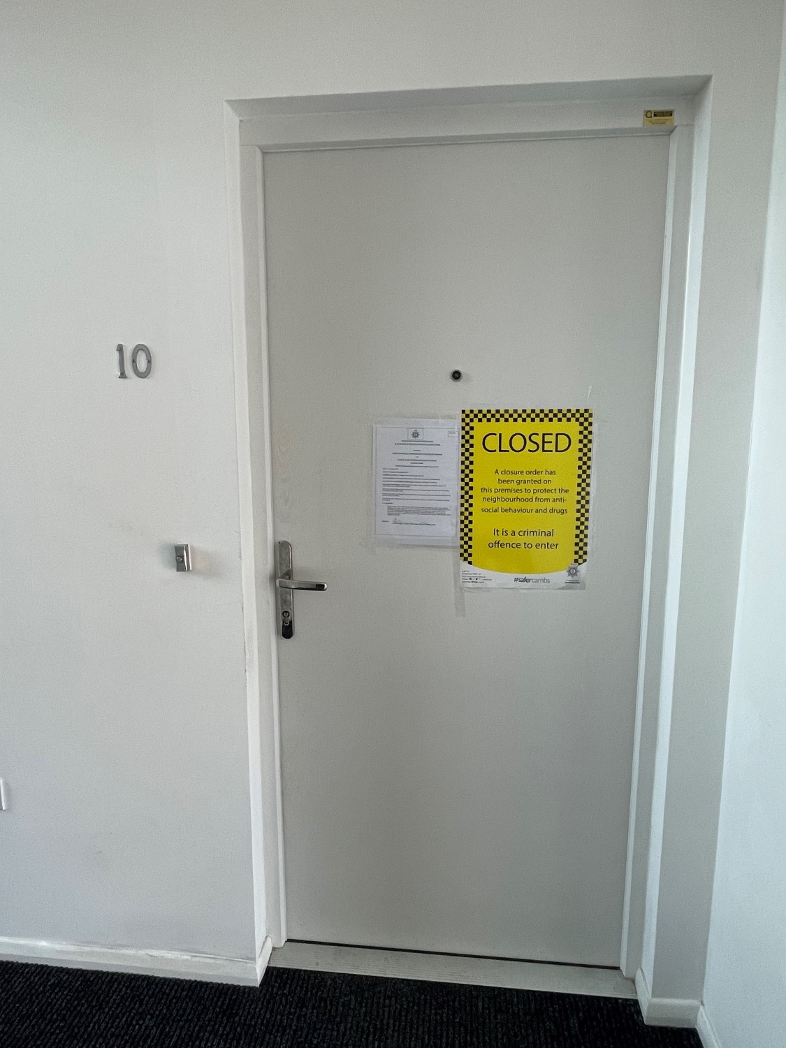 A white front door with a closure order attached