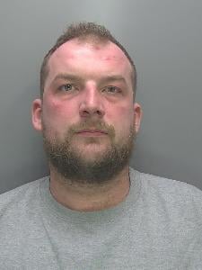 A custody photo of a dishevelled man. 