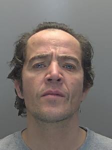 A custody photo of a man looking unhappy. 