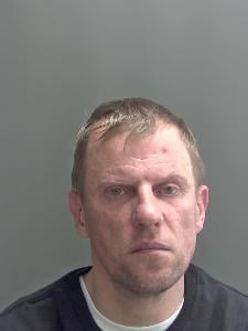 A custody photo of a man looking unhappy. 