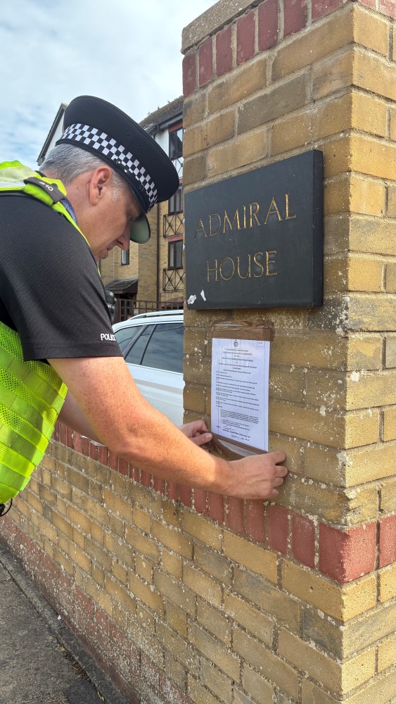 Police officer putting up closure order signs