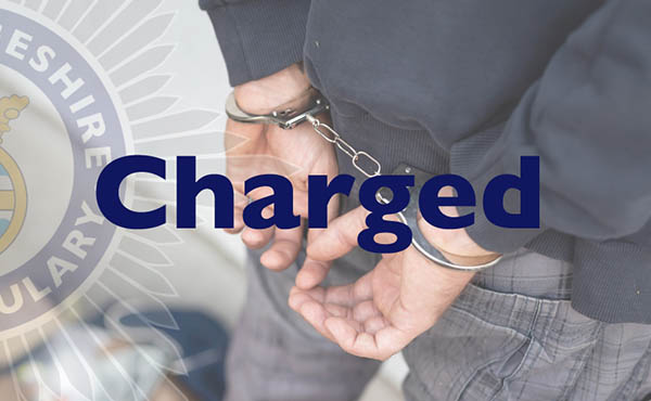 Close up of a man's hands in handcuffs with charged text overlaid